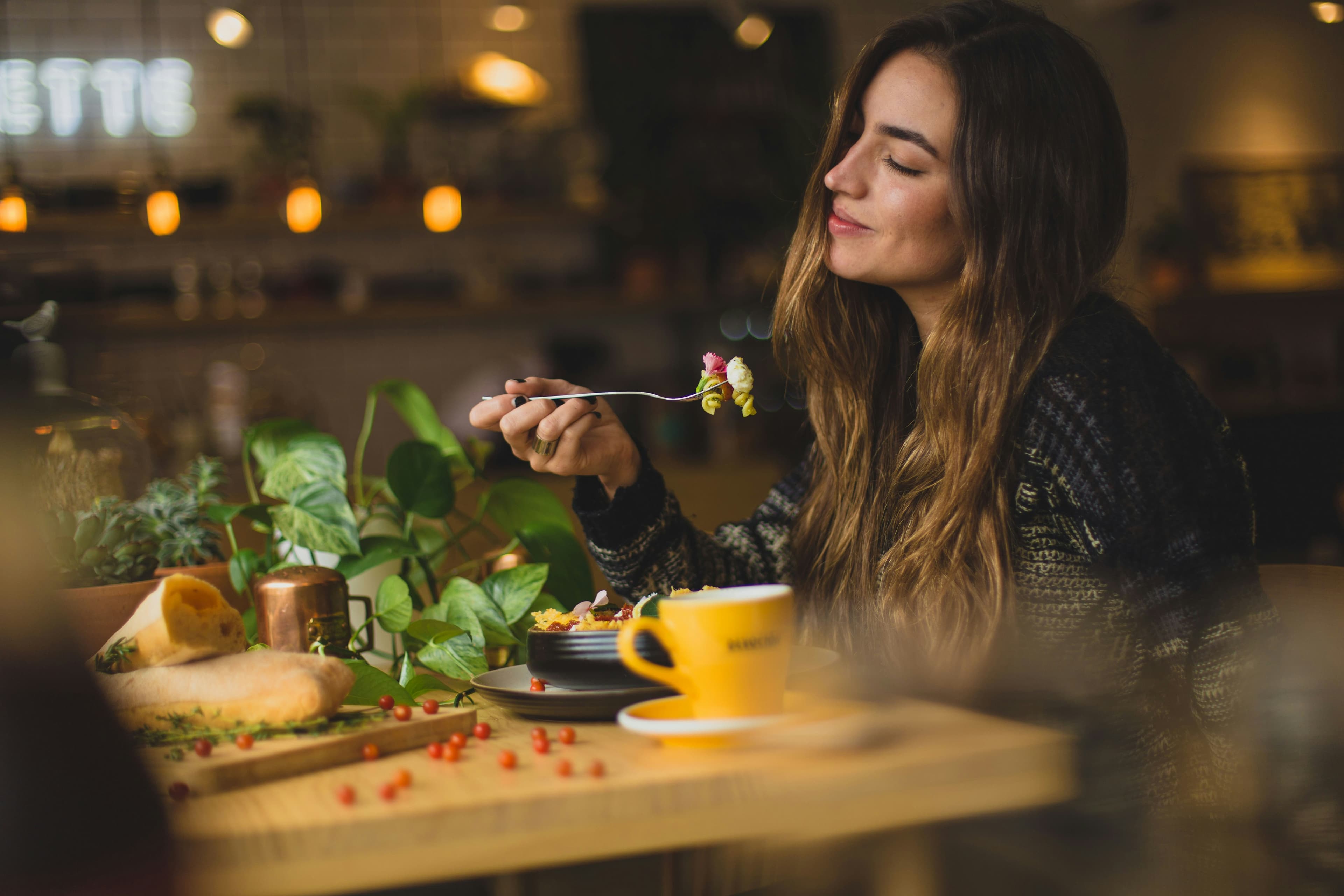 Lady is eating a veggie meal